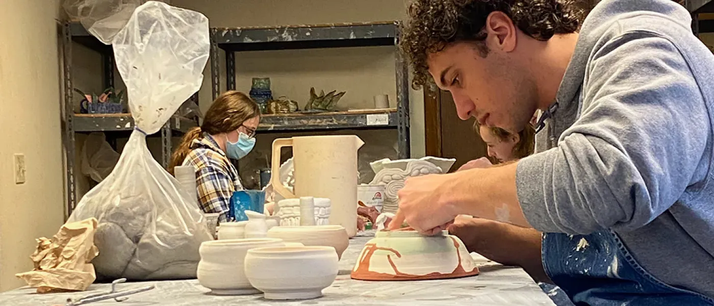 U N E student making pottery