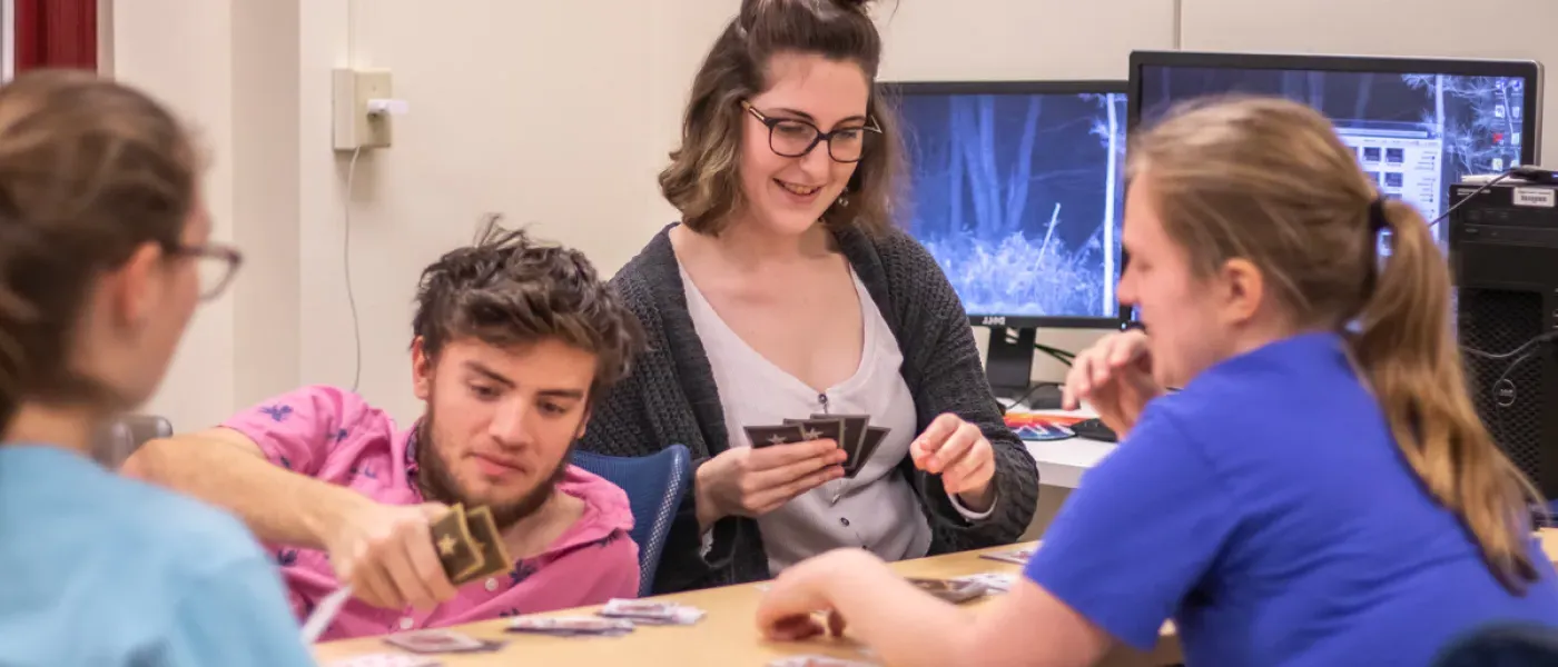 Four students playing a card game